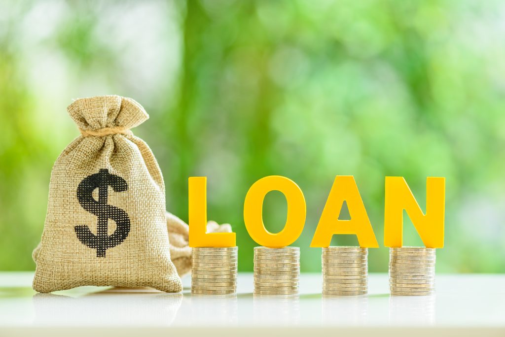Consumer and personal loan, financial concept : Loan bags, row of coins with the word LOAN on a table, depicting financial flexibility for life's expenses, unlock borrower's goal with personal loan.